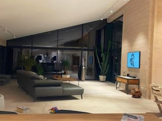 Moderne Blockbohlenhaus-Gaststube mit elegantem Design, großen Fenstern und ästhetischen Holzdetails von FINNHOLZ.