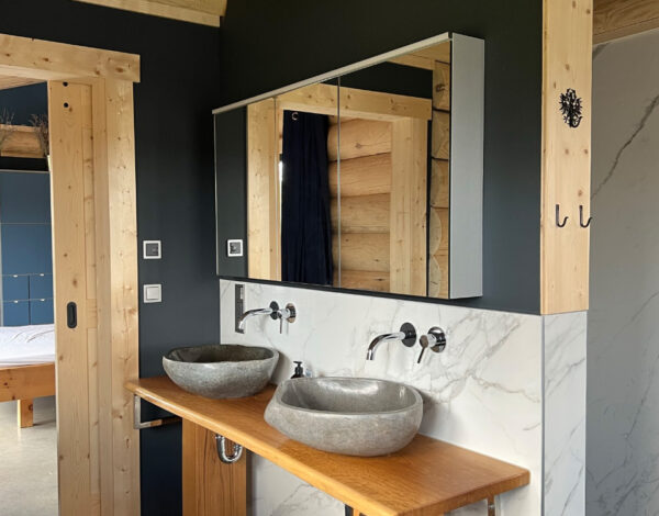 Modernes Badezimmer mit natürlichen Materialien im FINNHOLZ Rundbohlen-Blockhaus.