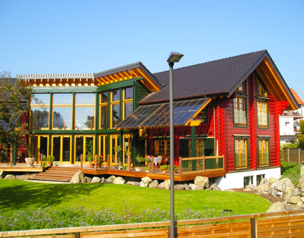 Ein sonnendurchflutetes FINNHOLZ Blockhaus mit Glasfronten und einer großzügigen Terrasse, gelegen in einer gepflegten Gartenanlage.