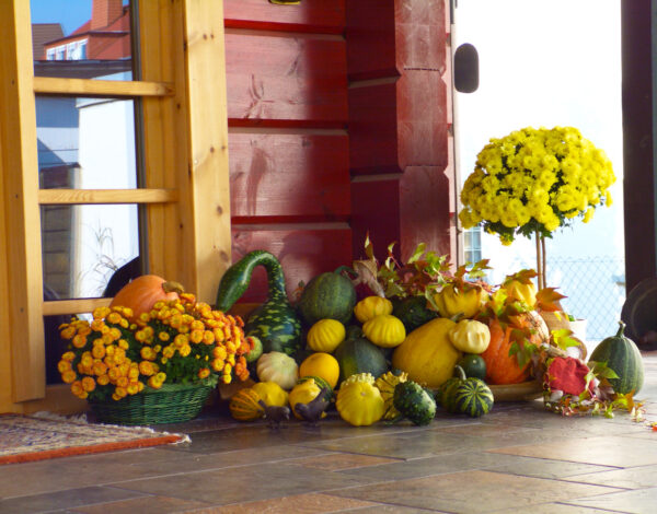 Herbstliche Dekoration am Eingang eines FINNHOLZ Blockbohlenhauses.
