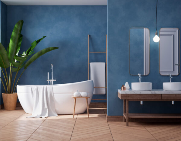 Stilvolles Badezimmer im Blockhaus von FINNHOLZ mit blauen Wänden und Holzakzenten.