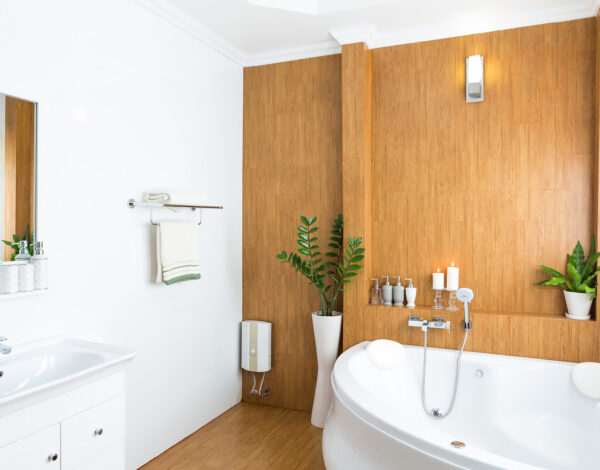 Helles Badezimmer mit Holzakzenten und Pflanzendekoration in einem FINNHOLZ Blockhaus.
