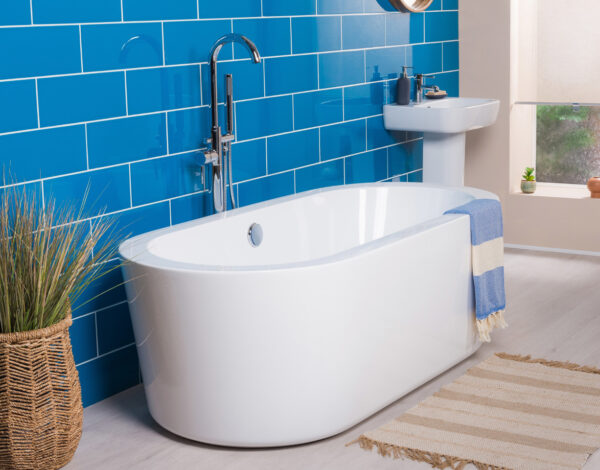 Moderne Badewanne in einem lebendig blauen Badezimmer eines FINNHOLZ Blockhauses.