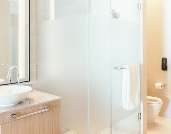 Helles und geräumiges Badezimmer mit Glasdusche und Holzdetails in einem FINNHOLZ Blockhaus