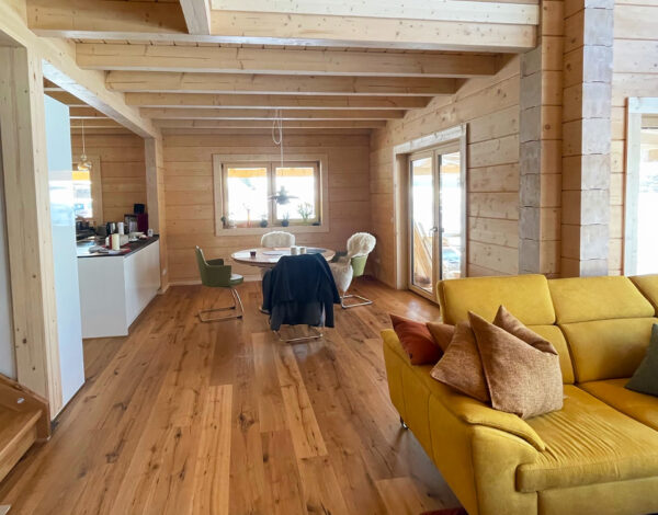 Helles, modernes Wohnzimmer im Blockbohlenhaus von FINNHOLZ mit elegantem Holzinterieur.