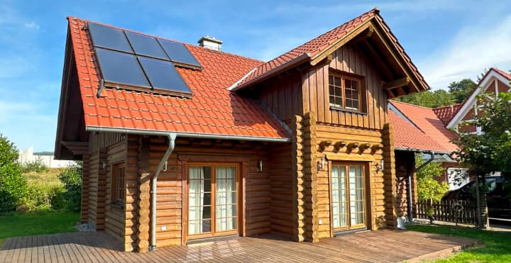 Gemütliches Blockhaus aus Rundbohlen von FINNHOLZ mit Solardach in idyllischer Umgebung.