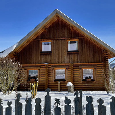 Finnholz Blockhaus aus Rundbohlen im verschneiten Winter