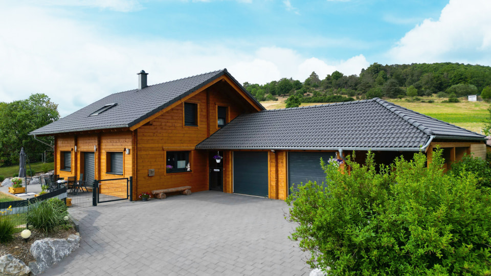Moderner Holzbau von FINNHOLZ mit grauem Dach und Garage