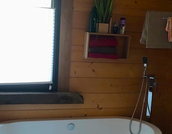 Modernes Badezimmer mit freistehender Badewanne in einem FINNHOLZ Blockhaus.