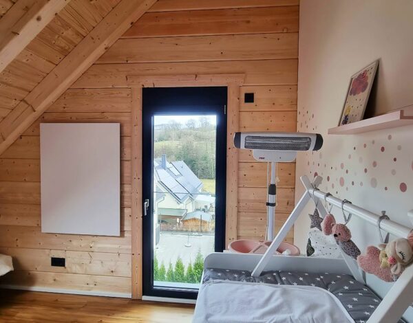 Helles und freundliches Kinderzimmer im FINNHOLZ Blockbohlenhaus mit sichtbaren Holzbalken und großen Fenstern, die den natürlichen Charakter des Holzhauses betonen.