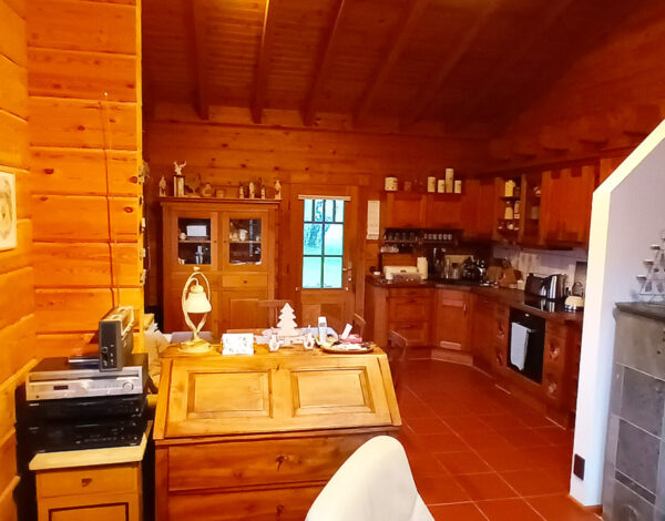 Traditionelles Blockhaus von FINNHOLZ mit gemütlich eingerichteter Küche und ländlichem Charme.