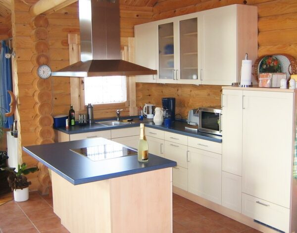 Küche mit Insel in einem Rundbohlenhaus von Finnholz.