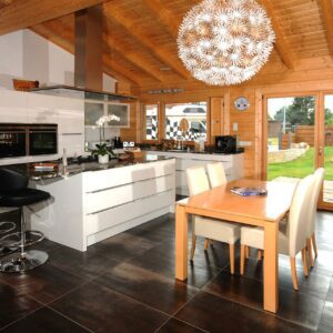Blick auf eine helle, weiße Küche in einem Vierkantbohlenhaus von Finnholz.