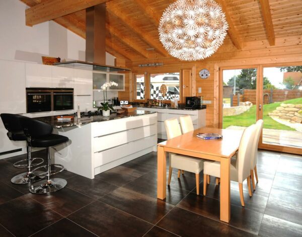 Blick auf eine helle, weiße Küche in einem Vierkantbohlenhaus von Finnholz.