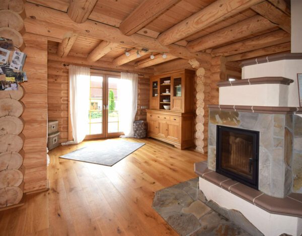 Wohnzimmer mit Kamin in einem Rundbohlenhaus von Finnholz.