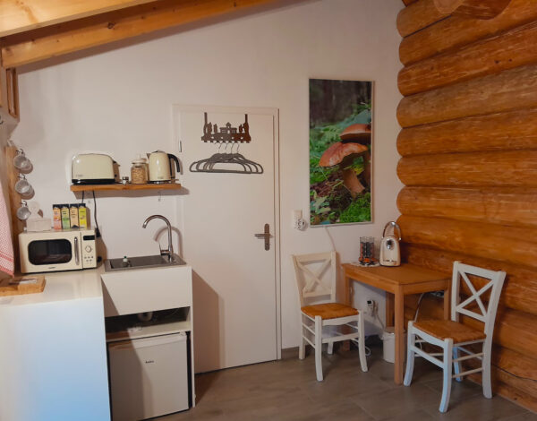 Kompakte und helle Küchenecke mit Rundbohlenwänden in einem FINNHOLZ Blockhaus.
