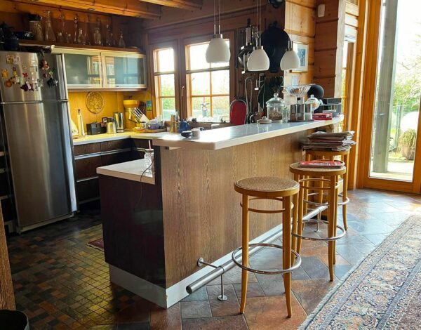 Moderne und gemütliche Küche im FINNHOLZ Blockbohlenhaus mit natürlicher Holzoptik und stilvoller Einrichtung.