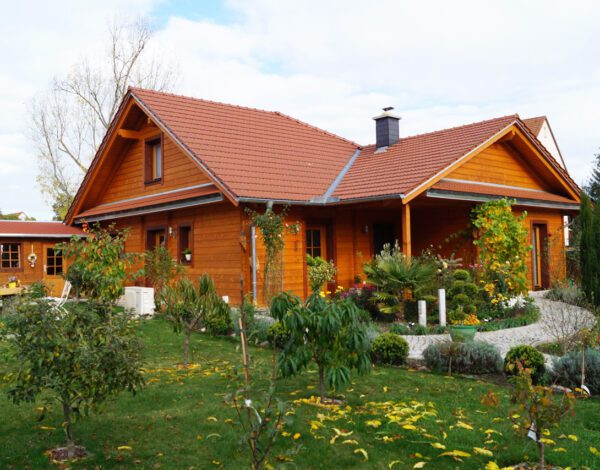 Einladendes FINNHOLZ Blockbohlenhaus mit gepflegtem Garten und charmanter Holzfassade aus Blockbohlen.