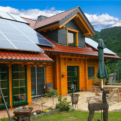 Nachhaltiges FINNHOLZ Blockhaus aus Blockbohlen mit Solarpanelen.