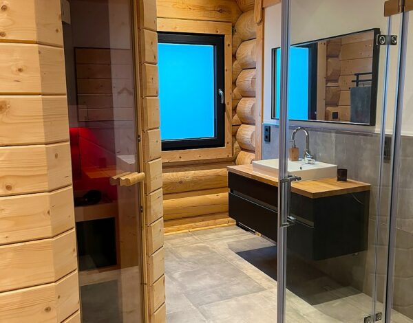 Modernes Badezimmer im FINNHOLZ Blockhaus, kombiniert mit traditionellen Rundbohlen.