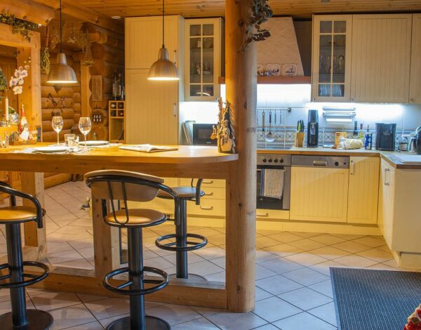 Gemütliche Blockhaus-Küche mit Bartheke von FINNHOLZ.