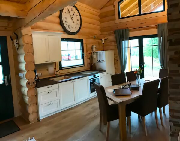 Küche und Essbereich in einem Rundbohlen-Blockhaus von FINNHOLZ mit modernen und traditionellen Elementen.