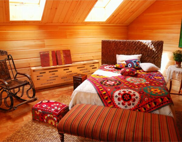 Gemütliches Schlafzimmer in einem Blockhaus von FINNHOLZ mit lebhaften Farben und traditionellem Dekor.