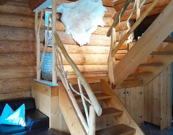 Holztreppe mit natürlichen Formen im Inneren eines FINNHOLZ Rundbohlenhauses.