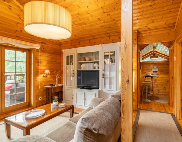 Stilvolles Wohnzimmer in einem Blockbohlenhaus, ausgestattet mit Naturholz und modernem Komfort.
