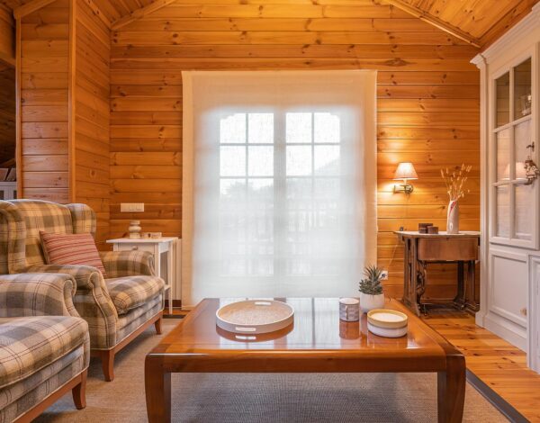 Gemütliches Wohnzimmer mit natürlichen Holzwänden und klassischen Möbeln im Blockhausstil.