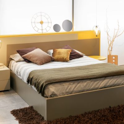 Modern gestaltetes Schlafzimmer mit warmen Farbtönen in einem FINNHOLZ Fertighaus.