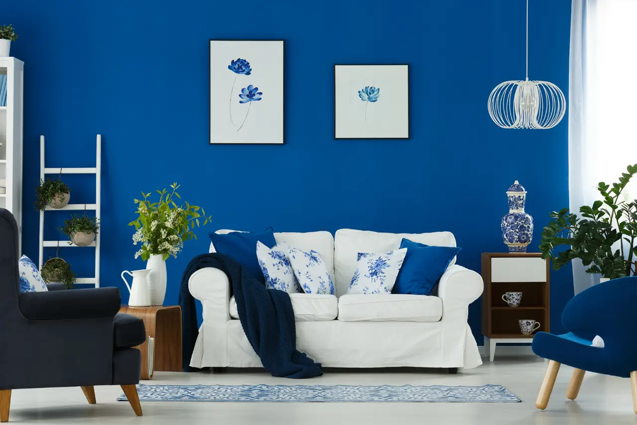 Maritim inspiriertes Wohnzimmer mit blauer Farbgestaltung und weißem Sofa in einem FINNHOLZ Fertighaus.