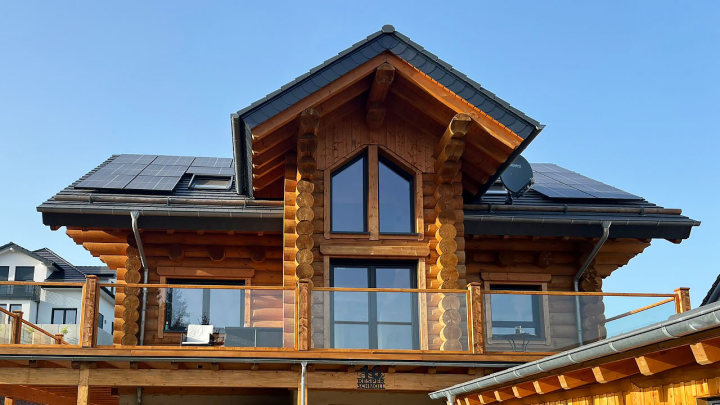 Rundbohlen-Blockhaus von FINNHOLZ mit Solarpaneelen.