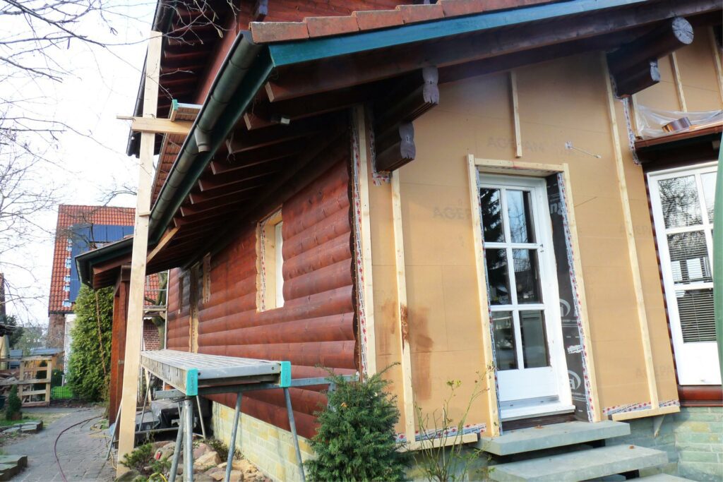 Fortsetzung der Holzfasadenmontage am FINNHOLZ-Holzhaus mit sichtbarem Weichfaserplatte-Windschutz.