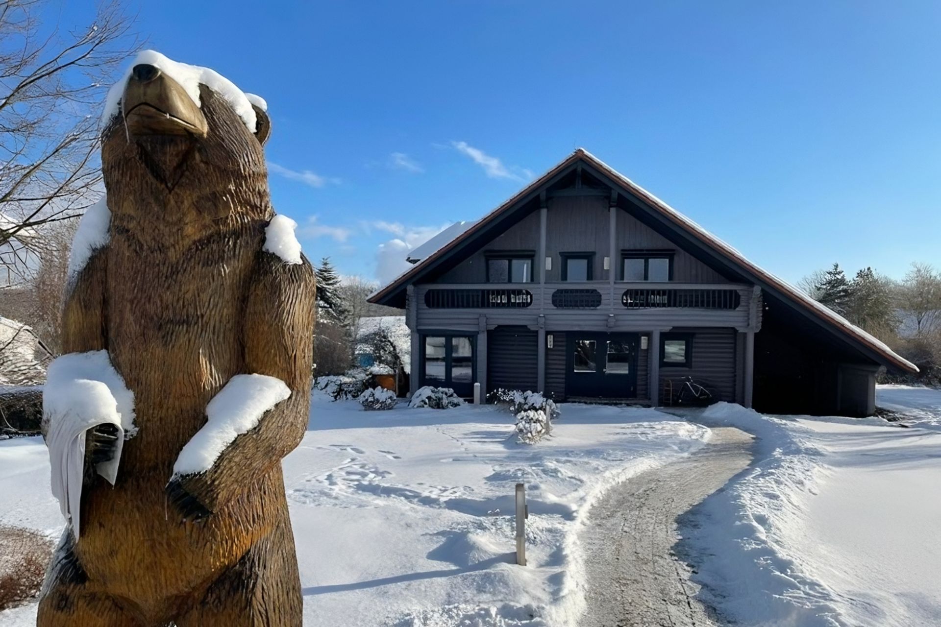 Winteransicht eines Finnholz-Blockhauses, komplett eingeschneit.