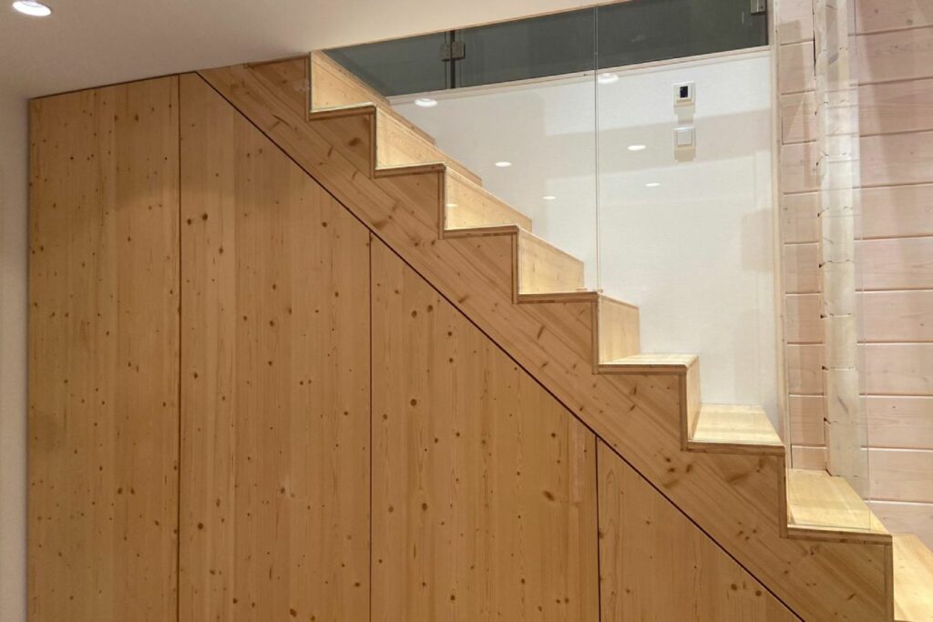 Moderne Holztreppe in einem Blockhaus mit integriertem Stauraum unter den Stufen.