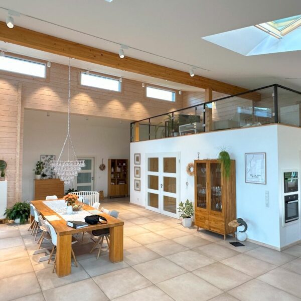 Helles, modernes Wohnzimmer im Blockhausstil mit natürlichen Holzelementen und großzügiger Verglasung.