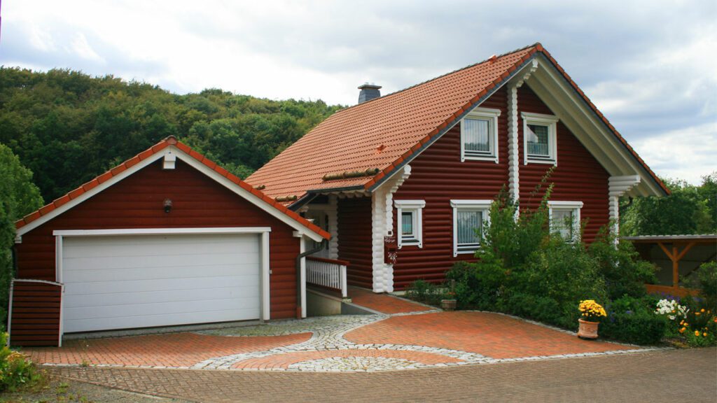 Rotes FINNHOLZ Holzhaus aus Rundbohlen mit passender Garage.